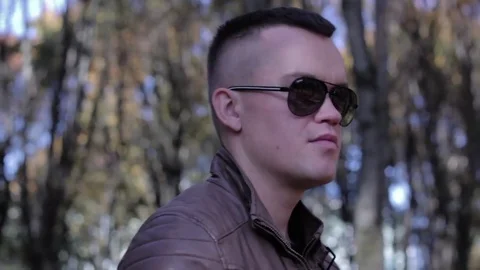 Serious confident man going and looking at camera in outdoors surrounding, close Stock Footage 81370905
