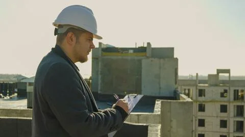 Serious construction manager in hard hat using a tablet for site inspection Stock Photos