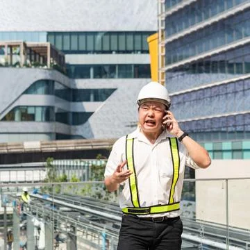 Serious construction supervisor talking on smartphone with worried expressi.. 스톡 사진