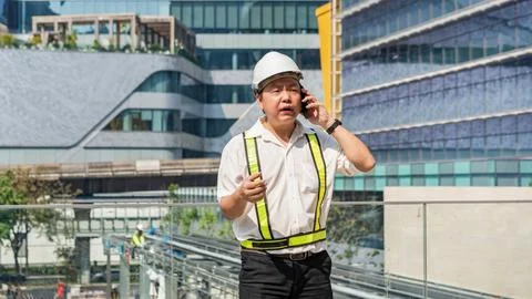 Serious construction supervisor talking on smartphone with worried expressi.. Stock Photos