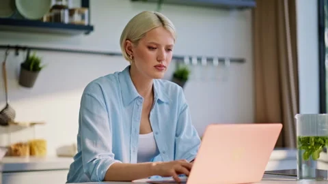 Serious copywriter typing computer sitting at apartment kitchen desk closeup Video stock 335151133