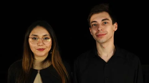 Serious couple looking at camera on black background Stock Footage 127530051