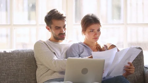 Serious couple talking having problem with paying bills on laptop Stock Footage