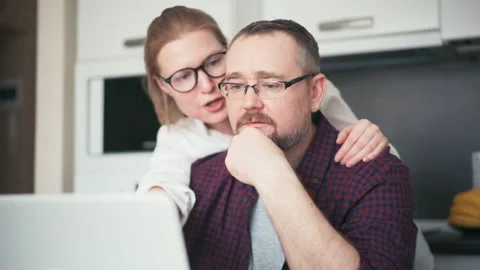 A serious couple talking while looking at a laptop screen Stock Footage 151936568
