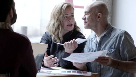 Serious designers working while sitting at table near window Stock Footage 121003389