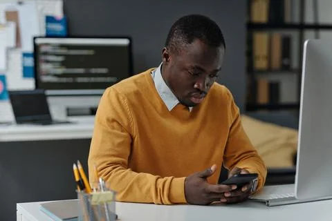 Serious developer using his smartphone at work Foto stock