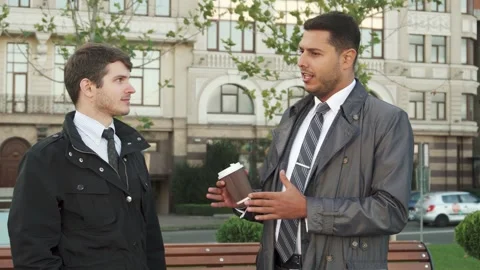 Serious discussion between two men in a park Stock Footage 311989428