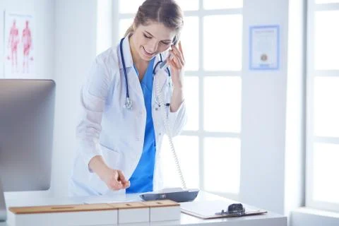 Serious doctor on the phone in her office Stock Photos