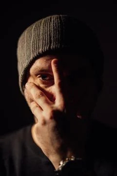 Serious dramatic man looking away while standing against black studio background Stock Photos