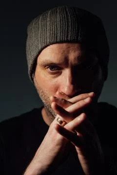 Serious dramatic man looking away while standing against black studio background 스톡 사진