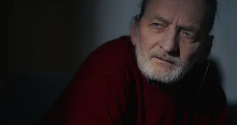 Serious elderly man in dark sweater with dramatic indoor lighting Stock Footage 336288646