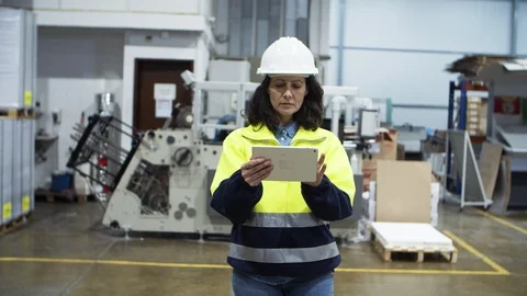 Serious engineer checking equipment while walking with tablet Stock Footage 127345215