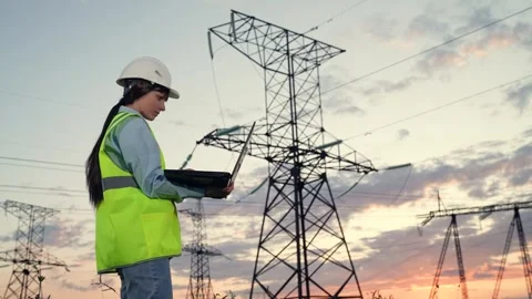 Serious engineer connects to network via laptop by power transmission lines Stock Footage 253324454