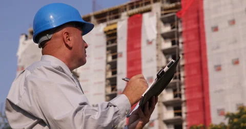Serious Engineer Inspecting Building Construction Site Take Notes in Work Agenda Video stock 68441177