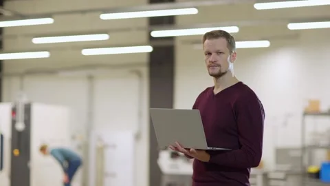 Serious engineer posing with laptop in lab Stock Footage 142159830