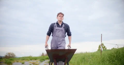 Serious Farmer With Wheelbarrow In Farm. Video stock 246830451