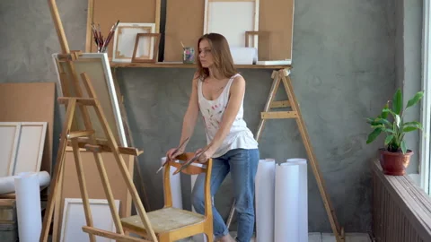 A serious female artist stands in a workshop facing a masterpiece of a talented Stock Footage 157706341