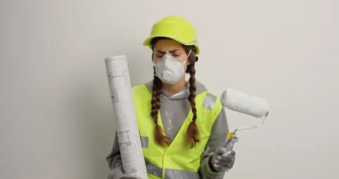 Serious female builder wears protective helmet uniform and respirator holds Stock Footage 156967621