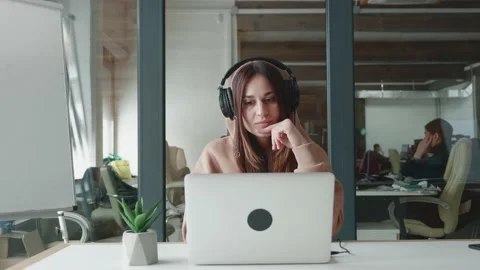 Serious female customer support agent wearing headset talking with client Stock Footage 149825529