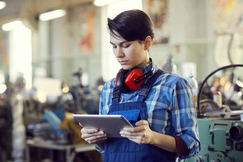 Serious female engineer using tablet in workshop Foto stock