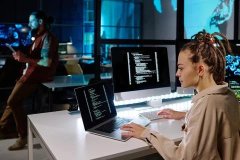 Serious female programmer with dreadlocks decoding data on laptop screen 스톡 사진