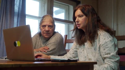 Serious Focus: Daughter Guides Intent Elderly Mother on Computer Task. Stock Footage 320326175