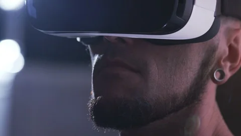 Serious focused guy with beard testing new gadget. Portrait of young man in Stock Footage 98190325