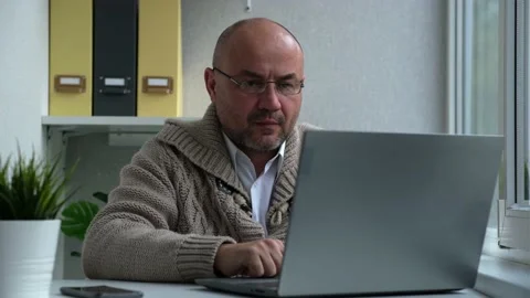 Serious focused middle aged man holding online video call with work colleagues Stock Footage 163322876