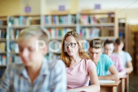 Serious girl sitting at lesson or seminar Stock Photos