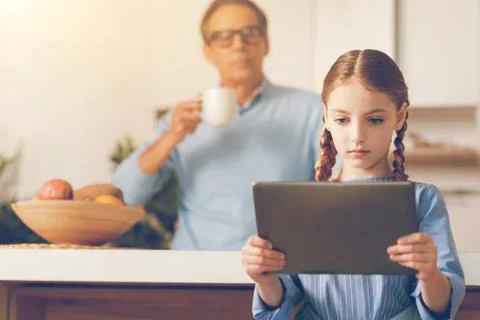 Serious girl using tablet computer at home Stock Photos