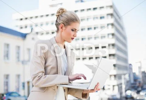 Serious gorgeous businesswoman holding laptop Stock Photos