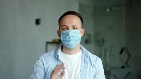 Serious guy with hand prothesis looks and puts on mask Stock Footage 157535950