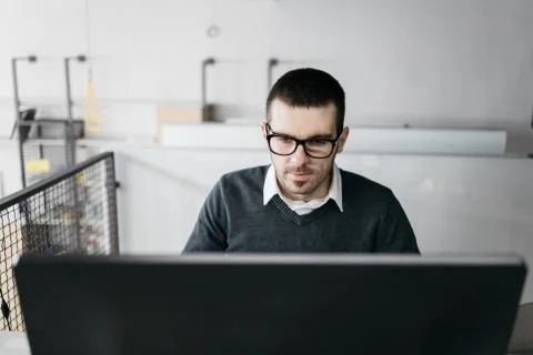 Serious guy looking into a computer desktop Stock Photos