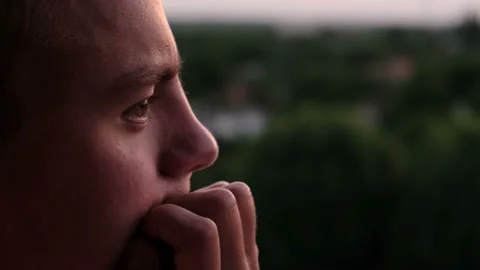 Serious guy thinking about something while standing on the balcony at sunset Stock Footage 109056791