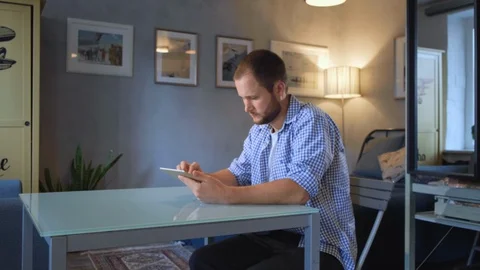 Serious guy is using tablet touching gadget screen Stock Footage 128584537