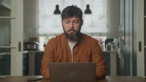 Serious guy working on the laptop computer indoors Stockbeeldmateriaal 200804796