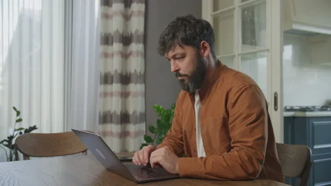 Serious guy working on the laptop computer indoors Stockbeeldmateriaal 201420707