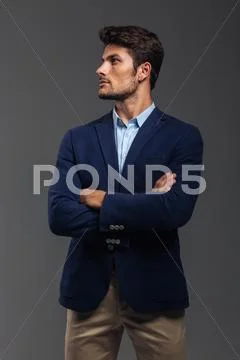 Serious handsome man with arms folded standing Stock Photos