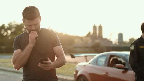 Serious handsome man with confused expression uses a smartphone calls for police Stock Footage 112988670