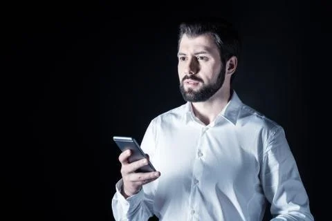 Serious handsome man using a smartphone Stock Photos