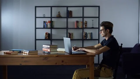Serious Handsome Man Writing Notes, Working with Laptop, Sitting in the Library Stock Footage 93301304