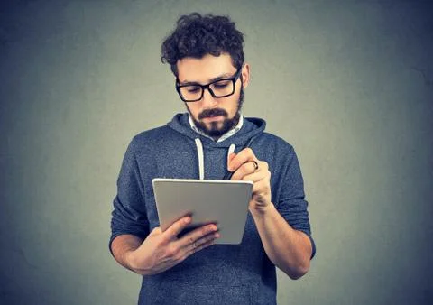 Serious hipster man using tablet computer Stock Photos