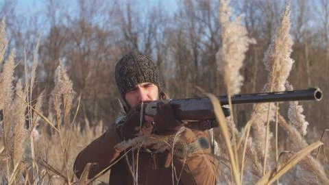 Serious hunter is focused on aiming at something. precise shot Stock Photos
