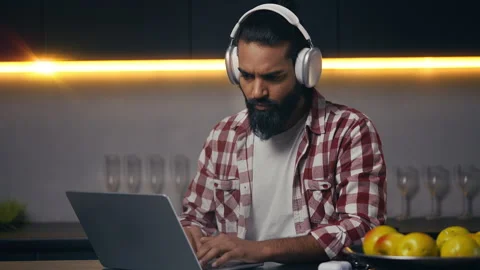 Serious Indian programmer in headset working on laptop, remote freelance project Stock Footage 316836260