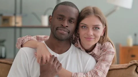 Serious Interracial Couple Hugging and Looking at Camera Stock Footage 287911054