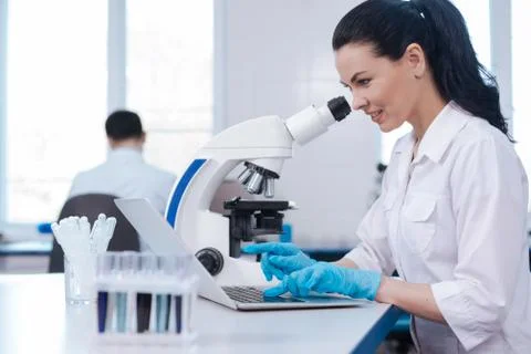 Serious lab assistant using her computer Foto stock