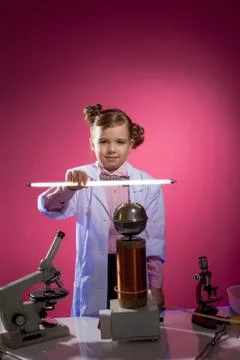 Serious little physicist shows focus with lamp Stock Photos