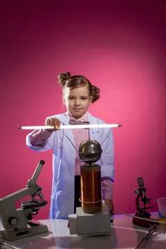 Serious little physicist shows focus with lamp Serious little physicist sh... Stock Photos