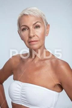 Serious looking female in white bra looking into camera Stock Photos