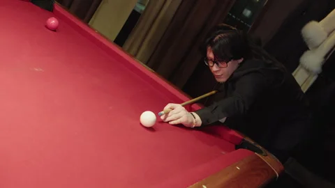 Serious male pool competitor keeps unwavering attention prior to shot by cue Video stock 329193006